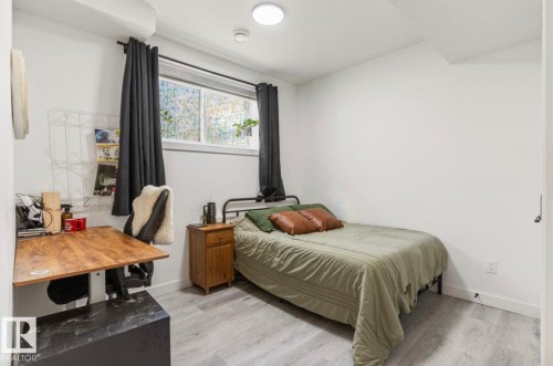 Light gray wood-finish flooring, recessed ceiling lighting, a window with privacy film, and white walls - 19703 29 Avenue Nw, Edmonton, AB 