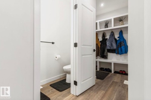 Built-in mudroom storage with hooks and shelving, recessed lighting, and wood-finish flooring - 19703 29 Avenue Nw, Edmonton, AB 