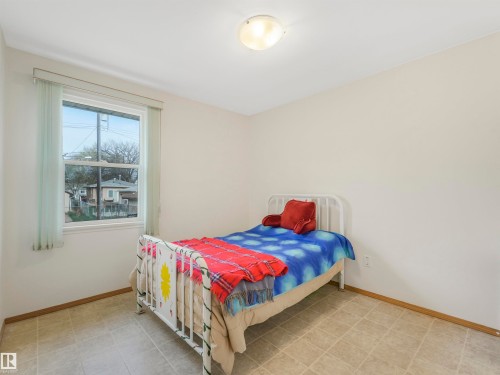 Recessed window with vertical blinds, flush mount ceiling light fixture, neutral wall paint, and square floor tiles - 12614 69 Street Nw, Edmonton, AB 