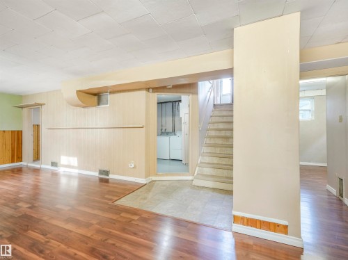 Wood-finish flooring, paneled walls, and a built-in staircase - 12614 69 Street Nw, Edmonton, AB 