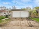 Two-car garage with white overhead doors and a gravel driveway - 12614 69 Street Nw, Edmonton, AB 