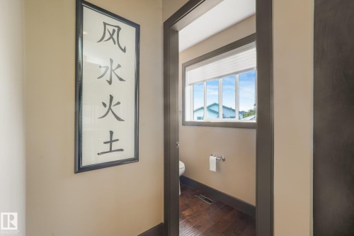 Powder room with wood-finish flooring, a toilet, a window with blinds, and neutral wall paint - 12827 150 Avenue Nw, Edmonton, AB 