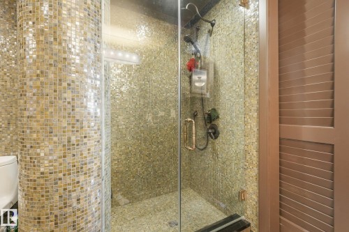 Glass-enclosed shower with full mosaic tile surround, built-in bench, and dual shower heads - 12827 150 Avenue Nw, Edmonton, AB 