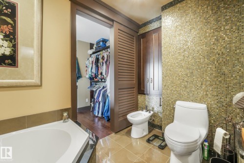 Built-in storage cabinetry, mosaic tile accent wall, and a separate bidet - 12827 150 Avenue Nw, Edmonton, AB 