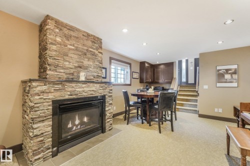 Stacked stone fireplace with a black surround and tiled hearth - 12827 150 Avenue Nw, Edmonton, AB 