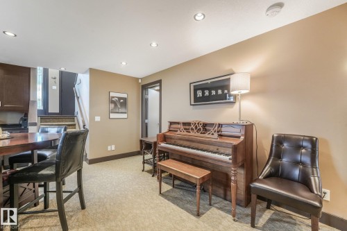 Recessed lighting, wood-finish cabinetry, built-in counter-height dining surface, staircase with wood railings, and a solid-core interior door - 12827 150 Avenue Nw, Edmonton, AB 