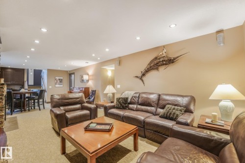 Recessed ceiling lighting, carpeted flooring, built-in cabinetry, and a stone-clad fireplace surround - 12827 150 Avenue Nw, Edmonton, AB 