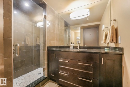 Glass-enclosed shower with tiled walls and pebble-finish floor - 12827 150 Avenue Nw, Edmonton, AB 