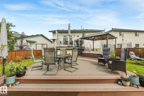 Multi-level outdoor deck with composite decking, integrated lighting, and a raised hot tub - 12827 150 Avenue Nw, Edmonton, AB 