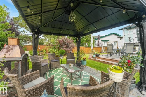 Outdoor gazebo with integrated lighting, paver patio, freestanding outdoor fireplace, and a raised wood deck - 12827 150 Avenue Nw, Edmonton, AB 