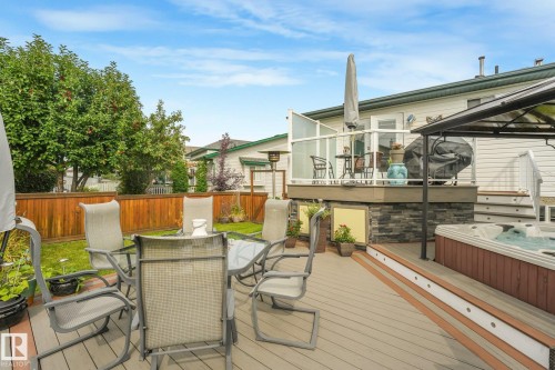 Multi-level composite deck with integrated lighting, a built-in hot tub, and glass panel railing - 12827 150 Avenue Nw, Edmonton, AB 