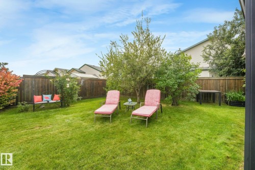 Expansive lawn area, established perimeter fencing, mature shrubs, and surrounding foliage - 12827 150 Avenue Nw, Edmonton, AB 