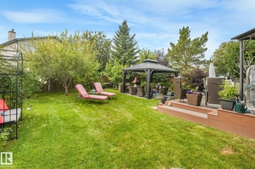 Expansive lawn area, mature trees, tiered wood-finish decking, and built-in gazebo - 12827 150 Avenue Nw, Edmonton, AB 