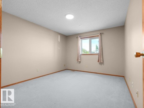 Neutral-toned walls complement the light gray carpeting and wood-finish trim - 535 Pardee Bay Nw, Edmonton, AB 