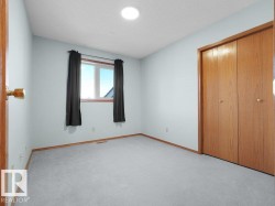 Second Bedroom - Recessed ceiling light, wall-to-wall carpeting, wood-finish bi-fold closet doors, and a window with wood-finish trim - 