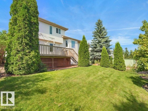 5- level split, back yard with a wood deck, lattice skirting, and a sloped lawn - 535 Pardee Bay Nw, Edmonton, AB 