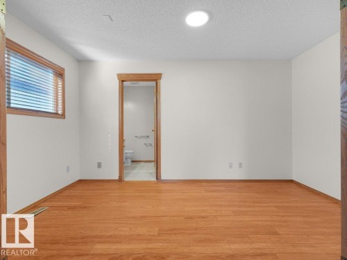 Wood-finish flooring, recessed lighting, and a window with wood trim - 535 Pardee Bay Nw, Edmonton, AB 