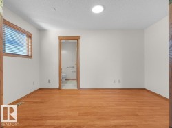Wood-finish flooring, recessed lighting, and a window with wood trim - 