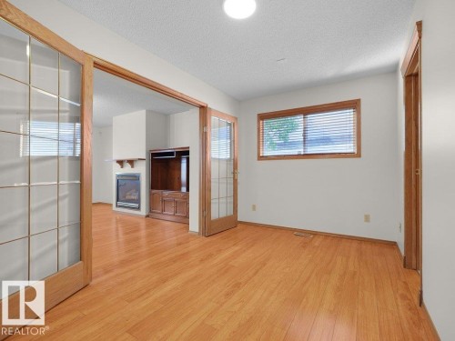 Wood-finish flooring throughout, with a window featuring horizontal blinds - 535 Pardee Bay Nw, Edmonton, AB 