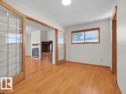 Wood-finish flooring throughout, with a window featuring horizontal blinds - 