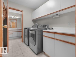 Laundry area with tile flooring, white cabinetry, and a countertop - 