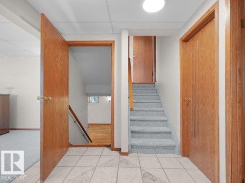 Tiled flooring entry with wood-panel doors, staircase with light-toned carpeting, and recessed lighting - 535 Pardee Bay Nw, Edmonton, AB 