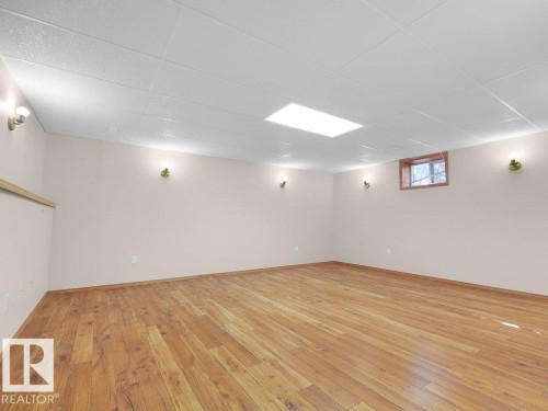 Wood-finish flooring, drop ceiling, recessed ceiling lighting, and wall-mounted sconces - 535 Pardee Bay Nw, Edmonton, AB 