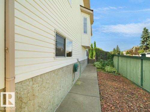 Exterior featuring horizontal siding, a bay window, stucco foundation, and a concrete pathway - 535 Pardee Bay Nw, Edmonton, AB 