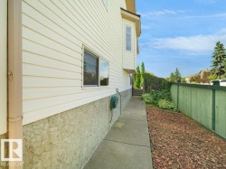 Exterior featuring horizontal siding, a bay window, stucco foundation, and a concrete pathway - 