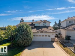 Two-story residence featuring a shingle roof, attached two-car garage, and a paved driveway with brick edging - 