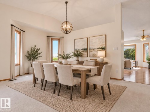 AI GENERATED PHOTO-Vaulted ceiling with an orb chandelier, bay window, light carpeting, wood-frame windows, and a hardwood flooring transition - 535 Pardee Bay Nw, Edmonton, AB 