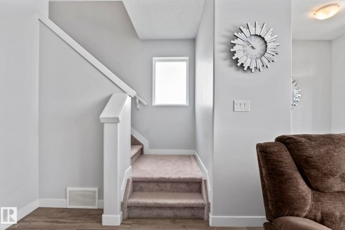 Carpeted staircase with white newel post and handrail - 10338 162St Nw, Edmonton, AB 