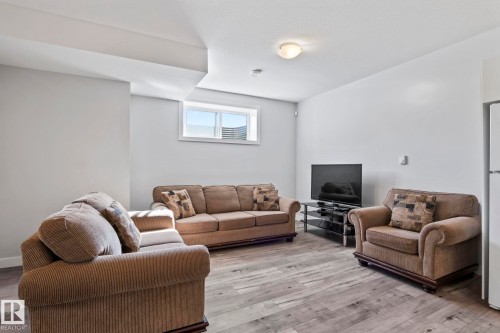 Recessed window with natural light, light gray wall paint, wood-finish flooring, ceiling-mounted light fixture, and textured ceiling - 10338 162St Nw, Edmonton, AB 