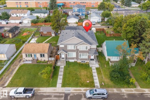 Duplex property featuring a grey exterior, dark grey shingle roof, and individual concrete pathways - 10338 162St Nw, Edmonton, AB 