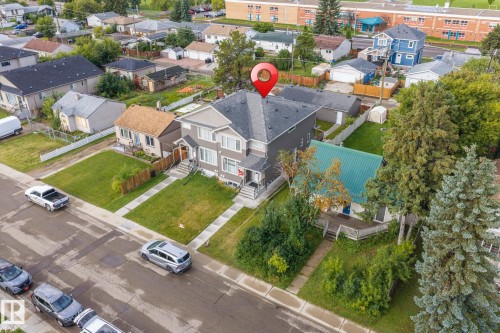Two-story residence with a gray exterior, dark shingle roof, and a front yard featuring a manicured lawn - 10338 162St Nw, Edmonton, AB 