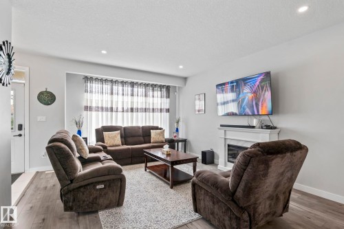 Recessed lighting illuminates the living space featuring wood-finish flooring - 10338 162St Nw, Edmonton, AB 