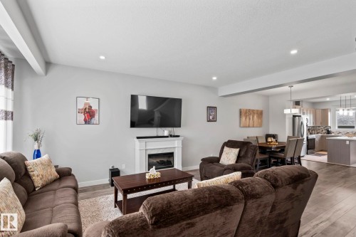 Recessed ceiling lighting, wood-finish flooring, white mantel, electric fireplace, and an open-concept layout - 10338 162St Nw, Edmonton, AB 