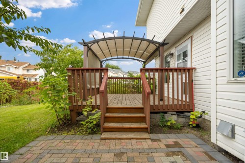 View of back yard with fruit trees, deck and stone patio - 6910 158A Avenue Nw, Edmonton, AB 