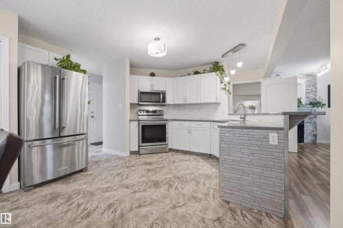 View of open-concept kitchen with updated appliances - 6910 158A Avenue Nw, Edmonton, AB 
