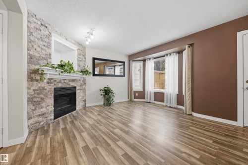 View from the living room of the open-concept main floor plan and gas fireplace - 6910 158A Avenue Nw, Edmonton, AB 