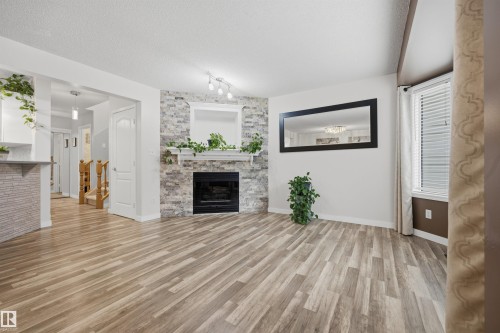 View from the living room of the open-concept main floor plan and gas fireplace - 6910 158A Avenue Nw, Edmonton, AB 