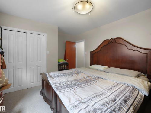 Carpet flooring, neutral painted walls, bi-fold closet doors, and flush mount lighting - 12002 48 Street Nw, Edmonton, AB 