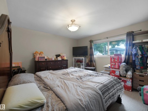Recessed ceiling light fixture, neutral wall paint, window with exterior landscape, carpeted flooring, and built-in shelving - 12002 48 Street Nw, Edmonton, AB 