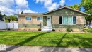 Exterior featuring a stucco and siding facade, covered entry, and established landscaping - 12002 48 Street Nw, Edmonton, AB 