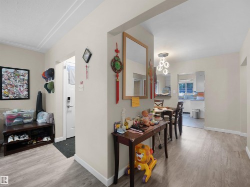 Wood-finish flooring throughout, with a contemporary ceiling light fixture in the dining area - 12002 48 Street Nw, Edmonton, AB 