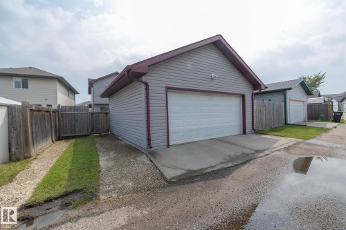 Detached garage featuring light grey siding, a white overhead door, and a brown trim roof - 17908 89 Street Nw, Edmonton, AB - Outdoor With Exterior
