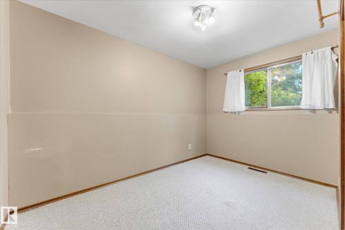 Recessed lighting, light beige walls, two-tone wall finish, and a window with a green outdoor scene - 11311 Malmo Road Nw, Edmonton, AB 