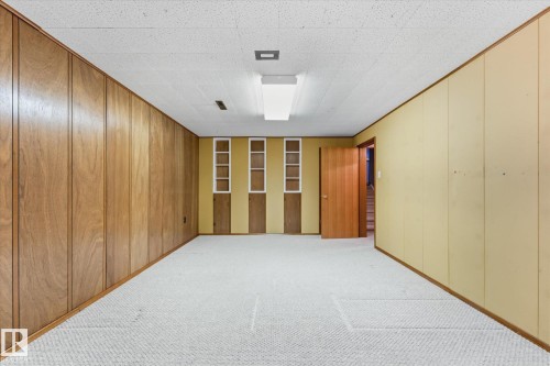 Recessed ceiling lighting, textured ceiling, built-in shelving, wood paneling, and wall-to-wall carpeting - 11311 Malmo Road Nw, Edmonton, AB 