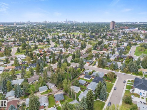 Mature treed neighborhood with residential properties and distant city skyline - 11311 Malmo Road Nw, Edmonton, AB 