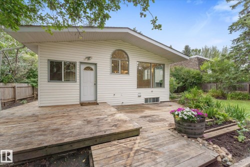 Exterior siding, large deck area, established landscaping, arched window, and a privacy fence - 11311 Malmo Road Nw, Edmonton, AB 